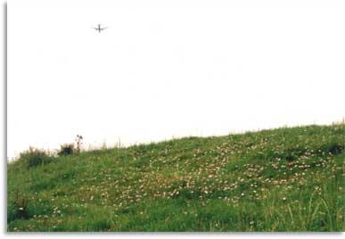 The top of Maes Knoll, with aircraft overhead.